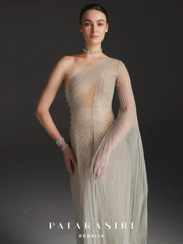 Patarasiri Regalia: a one-shoulder gown of fine pleated, shimmering tulle with a long draped sleeve