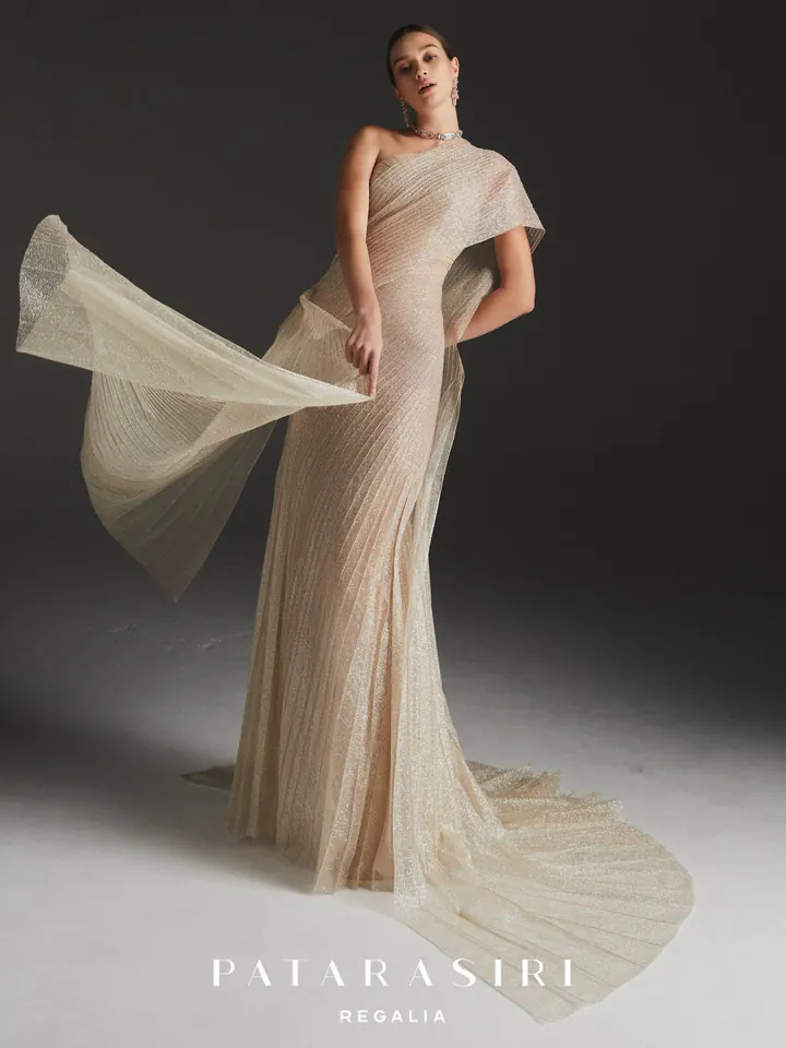 Patarasiri Regalia: a champagne column gown of pleated shimmer tulle, a panel of fabric lifting from the arm